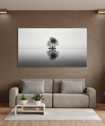 A Cottage house with dry trees behind in the middle of a lake and a clear reflection