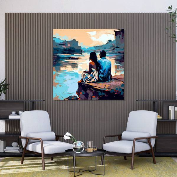 A couple sitting on cliff looking into the background having a Lake and other cliff edges.