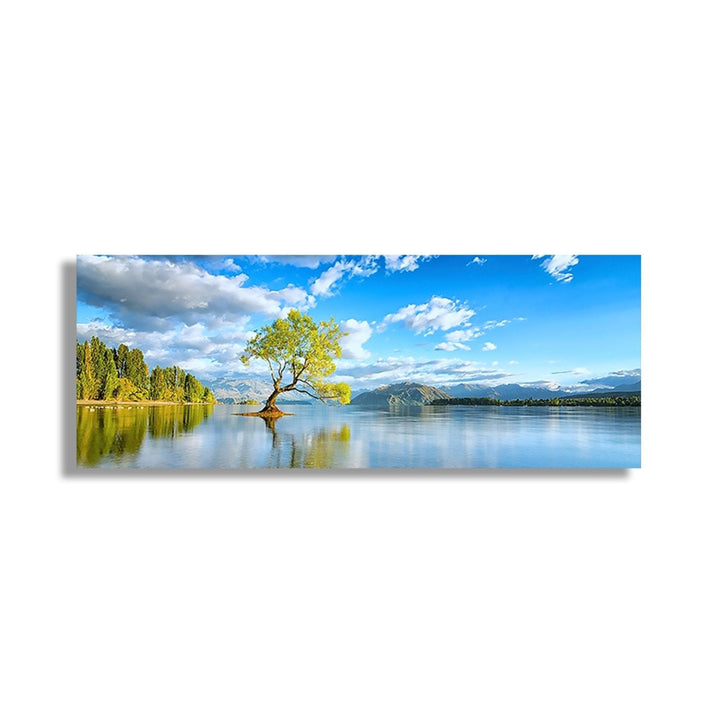 Tree in centre of lake , day scene, trees an dmountains in background 